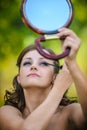 Young woman colouring her eyelids