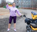 Young woman combines sport and a walk with baby