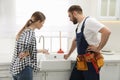 Young woman complaining to plumber about clogged sink Royalty Free Stock Photo