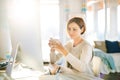 A young woman with computer and smartphone indoors, working in a home office. Royalty Free Stock Photo