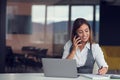 A young woman with computer and smartphone indoors, working in office. Royalty Free Stock Photo