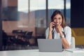 A young woman with computer and smartphone indoors, working in office. Royalty Free Stock Photo