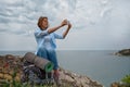 A young woman conquered the mountain top and decided to take a picture of a beautiful panoramic view