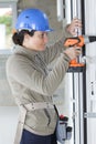 young woman construction worker drilling in house entrance Royalty Free Stock Photo