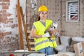 Young woman construction worker standing inside apartment Royalty Free Stock Photo