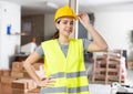 Young woman construction worker standing inside apartment Royalty Free Stock Photo