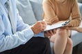 Young woman at a consultation with a psychotherapist. Psychologist having session with her patient in office, giving him Royalty Free Stock Photo