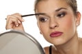 Young woman contouring her eyebrows with dry brush