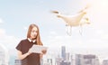 Young woman controlling a drone in big sunlit city Royalty Free Stock Photo