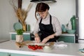 Young woman cook in an apron prepares homemade pizza at her leisure, her hobby is cooking food Royalty Free Stock Photo