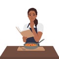 Young woman cook reading recipes and cooking soup Royalty Free Stock Photo