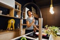 Young woman cooking a healthy meal in home kitchen.Making dinner on kitchen island standing by induction hob.Preparing fresh Royalty Free Stock Photo