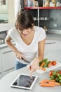 Young woman cooking at home using digital tablet for recipe Royalty Free Stock Photo