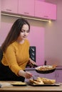 Young woman cooking in a kitchen. Housewife preparing vegetables for cooking. Girl put fresh fried meat into yellow zucchini. Royalty Free Stock Photo