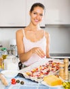 Young woman cooking pizza with salami Royalty Free Stock Photo