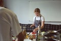 Young woman cooking in restaurant kitchen during cooking classes Royalty Free Stock Photo