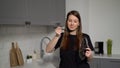 A young woman is cooking soup in the kitchen. Girl opens lid of pot and try food Royalty Free Stock Photo