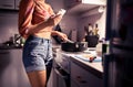 Young woman cooking and using phone. Person preparing a dinner and texting with smartphone. Diet or healthy lifestyle.