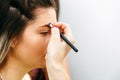 Young woman correcting eyebrow shape with brush, closeup Royalty Free Stock Photo