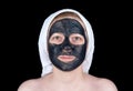 Young woman with a cosmetic scrub mask with activated charcoal on her face Royalty Free Stock Photo