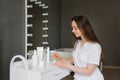 Young woman cosmetologist or dermatologist is sitting in the office of a beauty spa and kneading cosmetics for peeling. The