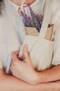 Young woman in cotton clothes embraces textile bag and lavender in paper as a concept of natural material, ecological production