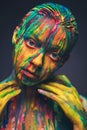 Young woman covered with a colourful paint