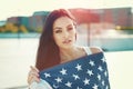 Young woman covered by star spangled banner in city Royalty Free Stock Photo