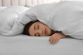 Young woman covered with warm white blanket sleeping in bed at home Royalty Free Stock Photo