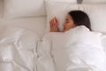 Young woman covered with warm white blanket sleeping in bed, top view. Space for text Royalty Free Stock Photo