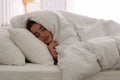 Young woman covered with warm white blanket sleeping in bed at home Royalty Free Stock Photo