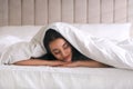 Young woman covered with warm white blanket sleeping in bed Royalty Free Stock Photo