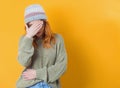 Young woman covering face with hand. Shame, isolated on yellow background. Ashamed girl Royalty Free Stock Photo