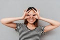 Young woman covering face with hands and peeking through her fingers Royalty Free Stock Photo