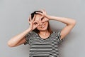 Young woman covering face with hands and peeking through her fingers Royalty Free Stock Photo