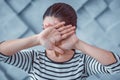 Young woman covering her face with crossed hands