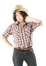 Young woman in a cowboy hat and plaid shirt with hand on her hat