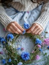 Young woman in cozy gray sweater making a wreath of wild flowers and herbs for midsummer celebration. Generative AI