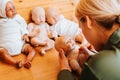 Young woman craftsman decorating realistic reborn dolls while sitting in workshop at home, back view. Royalty Free Stock Photo