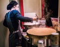 Young woman crepe chef cooking over crepe griddles in Montmartre cafe Royalty Free Stock Photo