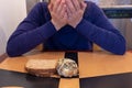 Young woman cries and buries her head and face while sitting at a kitchen table with a scone and toast. Concept for dieting and Royalty Free Stock Photo