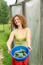Young woman with crop of cucumbers
