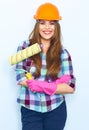 Young woman with crossed arms holding painting roller