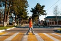 A young woman crosses a pedestrian crossing. Empty road and streets. Side view. Concept of traffic rules Royalty Free Stock Photo