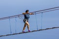 Young woman crossing a chasm on a rope bridge Royalty Free Stock Photo