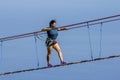 Young woman crossing a chasm on a rope bridge Royalty Free Stock Photo