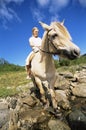 Young woman crossing a river by horse Royalty Free Stock Photo