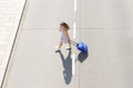 Young woman crossing street with mobile phone and suitcase Royalty Free Stock Photo