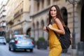 young woman crossing a street with traffic with her backpack on her back Royalty Free Stock Photo