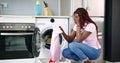 Young Woman Crouching With Cleaned Clothes Royalty Free Stock Photo